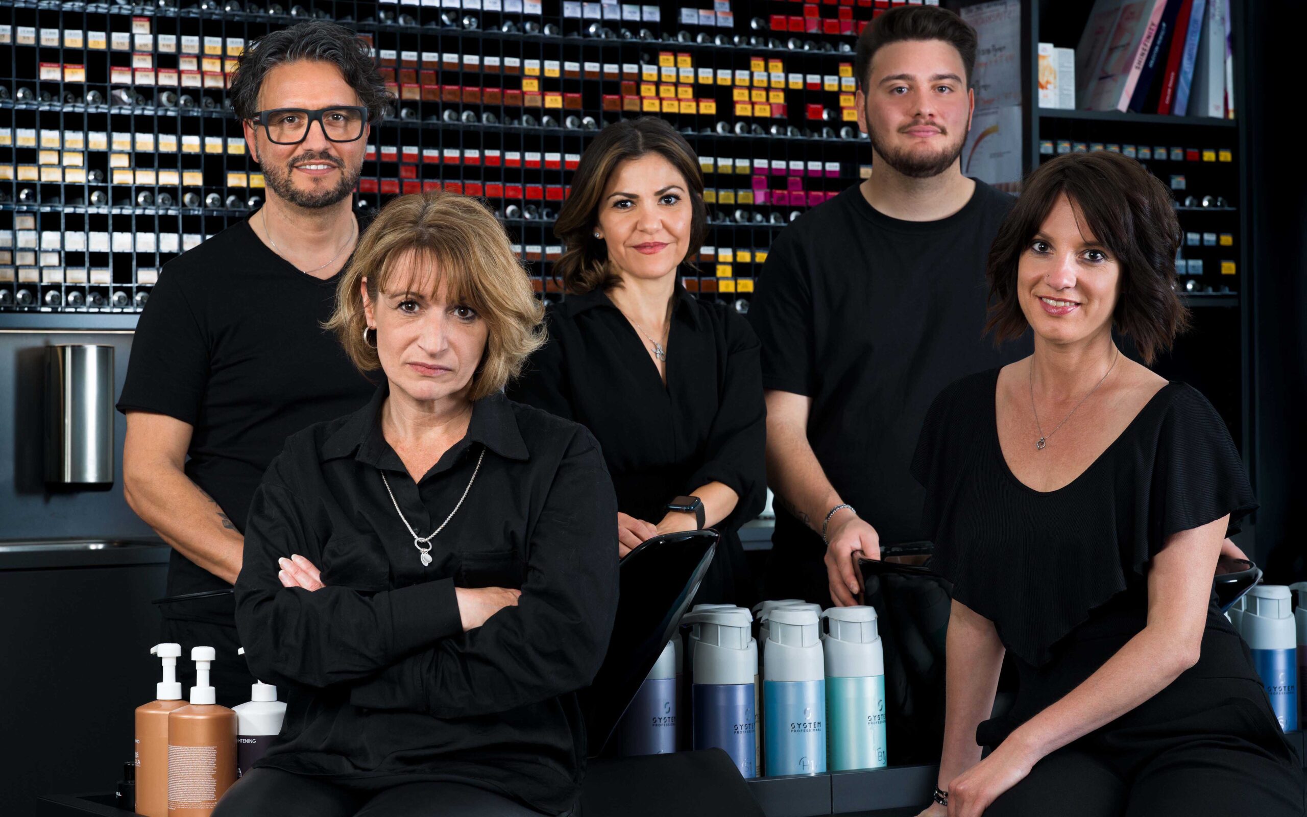 Team Coroneo Hair Deign in Erkrath präsentiert die Galerie in Erkrath. 5 köpfiges Team sitzt und steht in ihrem Salon und schauen in die Kamera