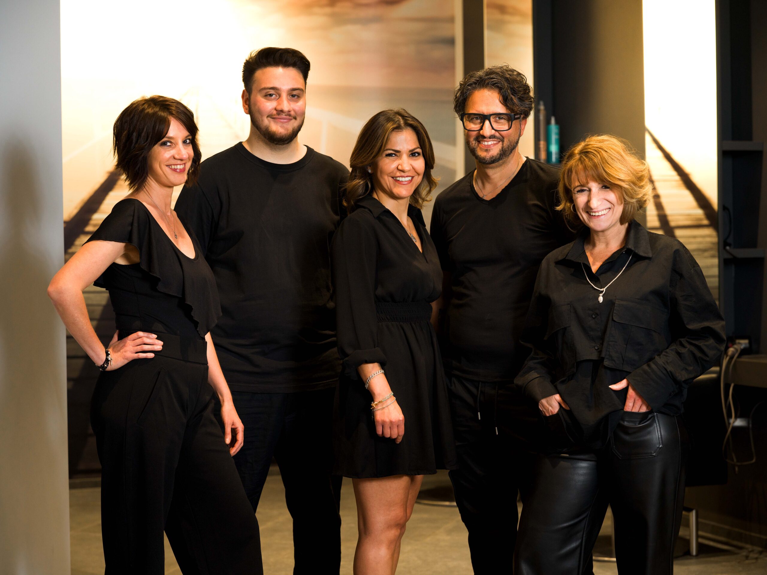 5 köpfiges Team von Rocco Coroneo Hair Design in Erkrath. 5 schwarzbekleidete Friseure lächeln in die Kamera