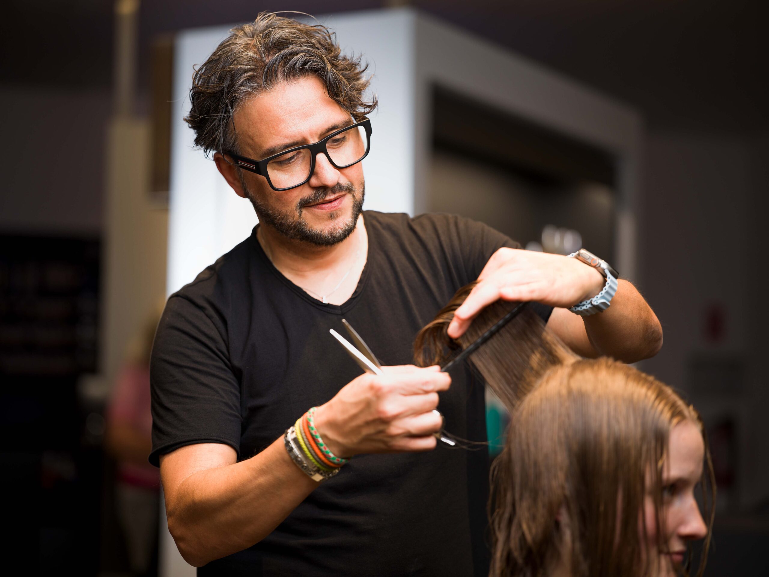 Rocco Coroneo schneidet die Haare einer blonden jungen Dame